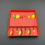 طقم ملاعق وشوك تقديم معدنية مزخرفة بأشكال الفواكه (Stainless Steel Fruit-Topped Flatware Set).